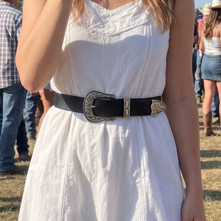 Woman wearing the Merle Belt over a white dress at a rodeo